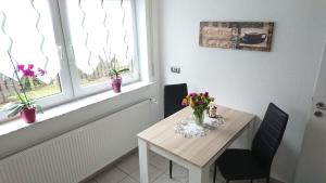 a dining room table with a vase of flowers on it at Gästehaus Ballmann 2 in Rockeskyll