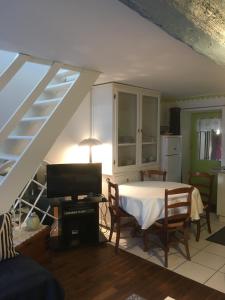 ein Wohnzimmer mit einem Tisch und einer Küche in der Unterkunft Gîte Les Lutins Bleus in Guillac