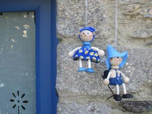 Zwei Spielzeugfiguren hängen an einer Wand in der Unterkunft Gîte Les Lutins Bleus in Guillac