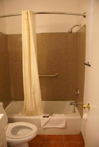 a bathroom with a toilet and a bath tub with a shower curtain at Harborview Inn & Suites-Convention Center-Airport-Gaslamp-Seaworld-Zoo-Balboa Park in San Diego