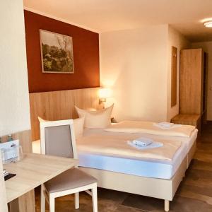 ein kleines Schlafzimmer mit einem Bett und einem Schreibtisch in der Unterkunft Hotel Reichskrone in Heidenau