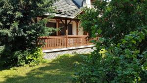 mały dom z drewnianym balkonem na dziedzińcu w obiekcie Mária Villa w mieście Balatonboglár +1 zdjęcie