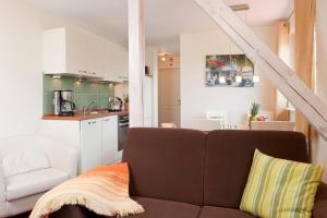 ein Wohnzimmer mit einem Sofa und einer Küche in der Unterkunft Gönndyr in Travemünde