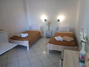 Pokój z dwoma łóżkami i stołem w obiekcie Εmmi w mieście Koutsounari