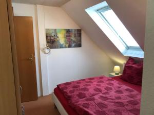 a bedroom with a bed with purple sheets and a window at Ferienwohnung mit Whirlpool in Ihlienworth