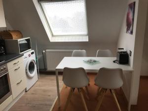 a kitchen with a table and chairs and a microwave at Ferienwohnung mit Whirlpool in Ihlienworth