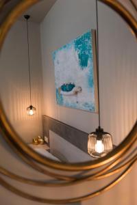 a mirror in a room with a painting on the wall at Wisdom Residence Luxury Apartments at Plaka in Athens