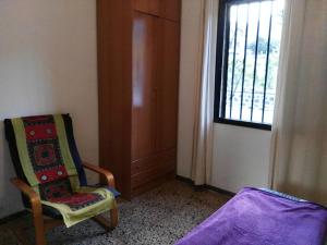een kamer met een stoel en een raam bij Donde Brilla el Sol in Candelaria