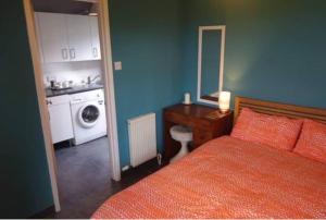 um quarto com uma cama, um lavatório e uma máquina de lavar roupa em Little Trenoweth em Saltash