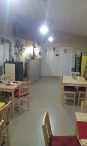 ein großes Zimmer mit Tischen und Stühlen sowie einer Küche in der Unterkunft Casa Cosmin in Dobra