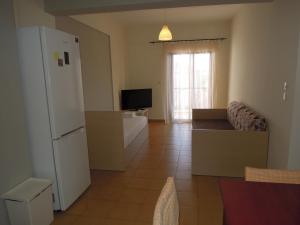 a living room with a white refrigerator and a couch at Erofili in Pefkochori