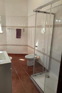 W łazience znajduje się toaleta i przeszklony prysznic. w obiekcie Spacious Central 2 Bedroom Apartment w mieście Setúbal