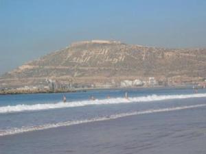 un gruppo di persone in acqua su una spiaggia di Agadir Holiday Apartment ad Agadir