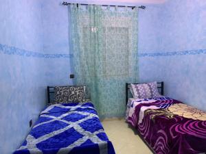 een slaapkamer met twee bedden en een raam bij Agadir Holiday Apartment in Agadir