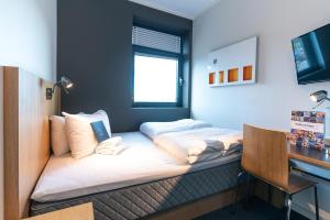 a room with a bed with a laptop on it at Smarthotel Forus in Stavanger