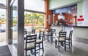um restaurante com um bar com cadeiras e um balcão em Beachtour Lux Sunset - Ericeira na Ericeira