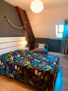 PierryにあるLe Gîte du Domaine Miltatのベッドルーム1室(カラフルな毛布付きのベッド1台付)