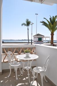 Apartamentos en Paseo Maritimo في إل رومبيدو: طاولة وكراسي على شرفة مع المحيط