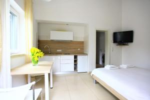 a small white room with a desk and a bed at Apartmani Val in Pula