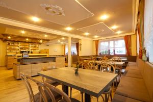 ein Restaurant mit Tischen und Stühlen und eine Küche in der Unterkunft Pension & Residence Astoria in Prad am Stilfserjoch