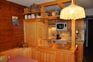 a kitchen with a table with a microwave and a lamp at Triolet in La Chapelle-dʼAbondance +29 photos