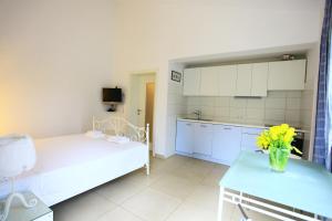 a room with a bed and a table with a vase of flowers at Apartmani Val in Pula