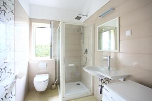 a bathroom with a shower toilet and a sink at Apartmani Val in Pula