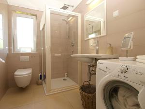 a bathroom with a washing machine and a sink at Apartmani Val in Pula