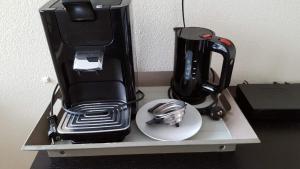 a black coffee maker sitting on top of a shelf at Logies21 Texel in Oosterend