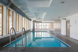 a swimming pool in a building with windows at #508 Cartwright - City Haven in Cape Town