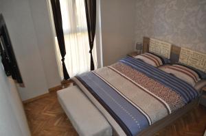 a bed sitting in a room with a window at Sofia Central Pretty Apartment in Sofia