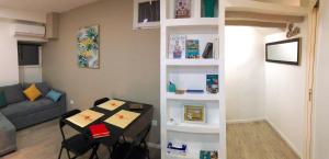 a living room with a table and a book shelf at 2 Pièces au coeur du quartier branché du port in Nice