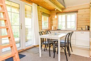 a kitchen and dining room with a table and chairs at Osupio Kopa in Šventoji