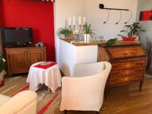 MezzegraにあるTremezzina Appartamento Red & Greyのリビングルーム(テレビ、テーブル、椅子付)
