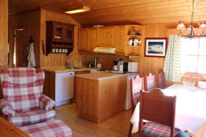 una cocina con armarios de madera, mesa y sillas en Ådnebu by Norgesbooking - cabin with 3 bedrooms en Geilo