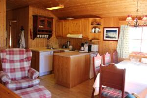 a kitchen with wooden cabinets and a table and chairs at Ådnebu by Norgesbooking - cabin with 3 bedrooms in Geilo