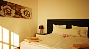 パタラバカにあるPanoramic 2 bedroom apartment over the Anfi beachのベッドルーム1室(花の絵が飾られたベッド1台付)