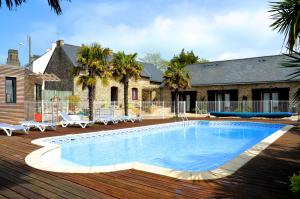 a swimming pool on a deck next to a house at Gîtes et Chambres - Les Buissonnets in La Turballe