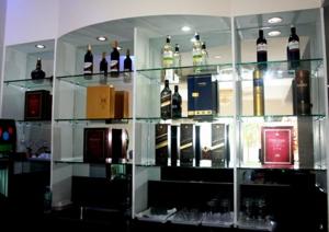 a glass shelf filled with bottles of wine at Cindy Kelly Hotel in Olongapo +14 photos