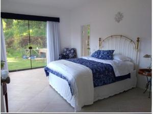 a bedroom with a bed and a large window at Zen in Itaipava +30 photos