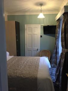 1 dormitorio con cama y puerta blanca en The White Lodge en Great Yarmouth