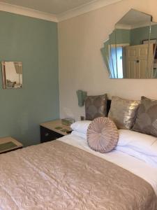 - une chambre avec un grand lit et un miroir mural dans l'établissement The White Lodge, à Great Yarmouth
