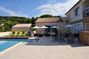 a house with a swimming pool with chairs and umbrellas at Résidence Château Saint Martin in Saint-Martin-dʼArdèche