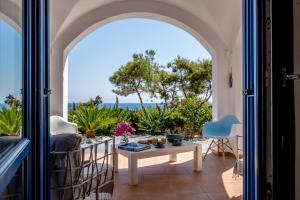 a room with a view of the ocean from a balcony at Santorini Mystique Garden Villa in Kamari