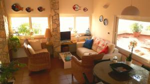 a living room with a couch and chairs and a table at VILLA LAURA MARIE in Porticello