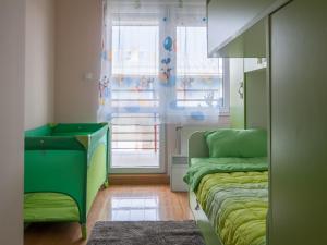 una camera con letto verde e finestra di Modern and bright apartment in Ruma a Ruma