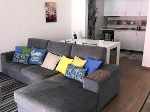 a living room with a gray couch with colorful pillows at Casa do Poeta in Setúbal