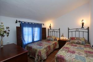 a bedroom with two beds and a window at Albara in Conil de la Frontera