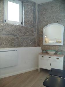 a bathroom with a white vanity and a window at Molarinho Heritage in Guimarães