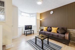 a living room with a couch and a tv at Alphalite Homes in Barking